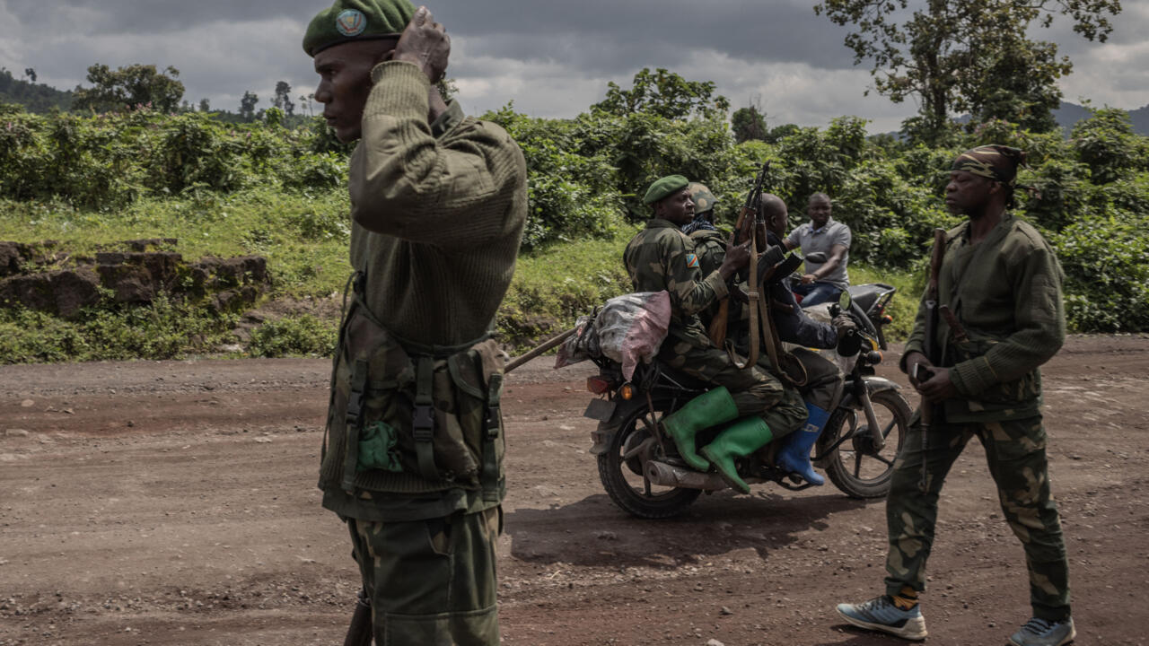 Un homme à moto transporte des soldats congolais à Kibumba, cible d'une attaque du M23, près de Goma, en République démocratique du Congo, le 1er juin 2022. AFP